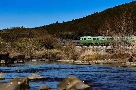 川沿いを走る緑の列車