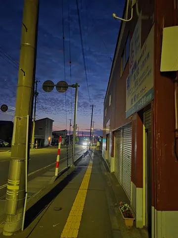 夕暮れ時、街灯が灯る道