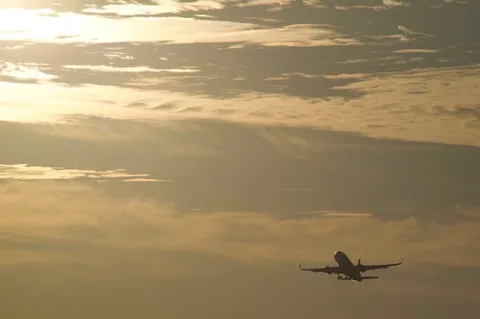 黄昏時の空を飛ぶ飛行機