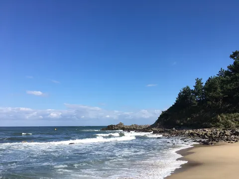 青い空と海、緑の丘のコントラスト