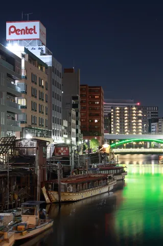 夜の運河を照らす緑の橋