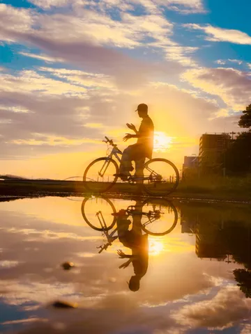 水面に映る夕焼けと自転車