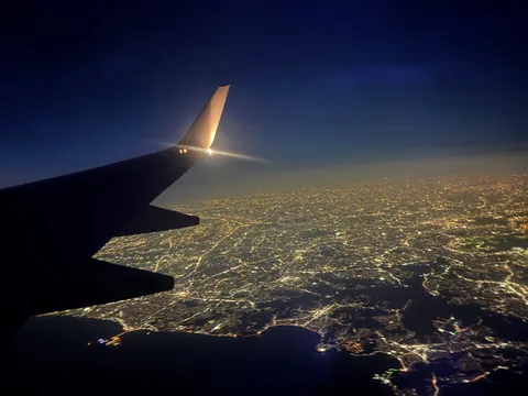 煌めく夜景と飛行機の翼