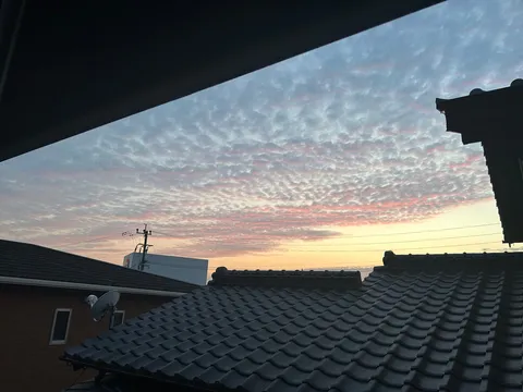 夕暮れの瓦屋根と雲の戯れ