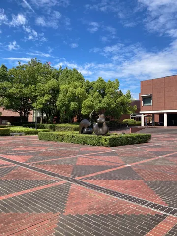 幾何学模様の広場と緑のオブジェ