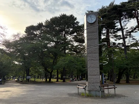 公園の時計塔と木漏れ日