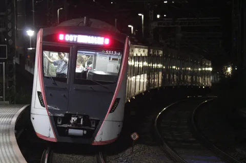 夜の線路を抜ける光の列車