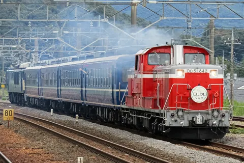 赤と青の列車、煙を上げて力走