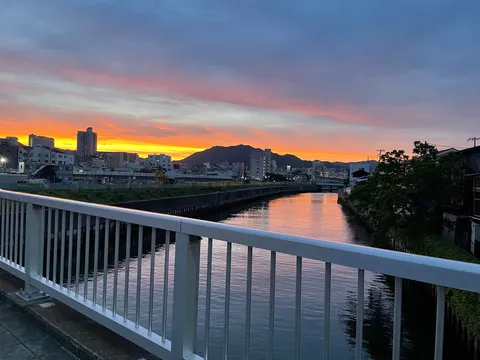 茜色に染まる都市の川辺