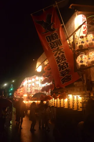 夜の赤旗と灯籠の祭り感