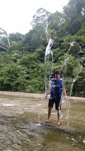 川辺の水しぶきと少年