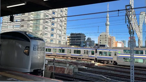都市をゆく電車と、空へ伸びる塔