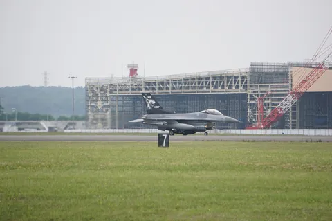 滑走路に立つ戦闘機、その先に広がる景色