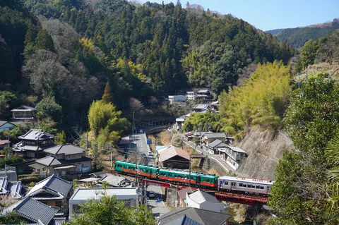 山間の集落を駆け抜ける列車