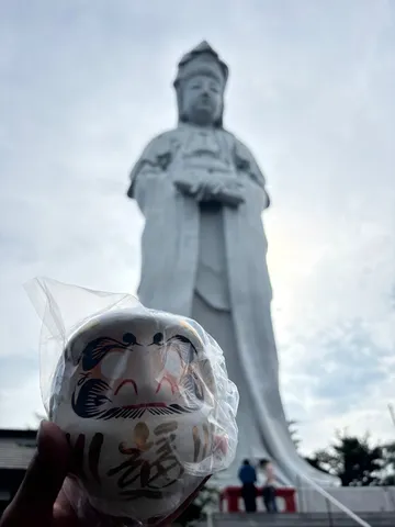 巨大な仏像と小さなだるま