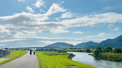 川沿いの散歩道、山並みと空