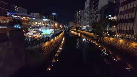 都会の夜景、水面に映る光の道