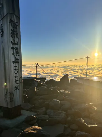 雲海に浮かぶ山頂、木製標識の御来光