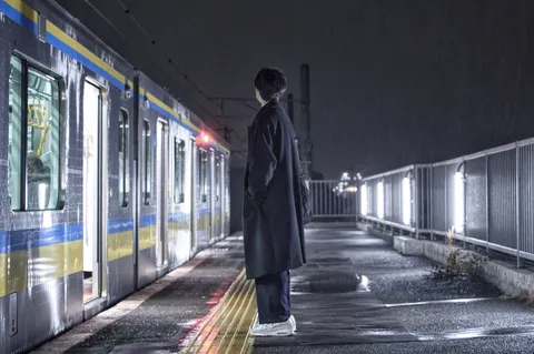 雨のホーム、青と黄色の列車