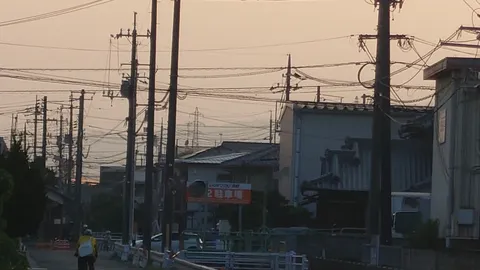 夕暮れ時、電線と家路