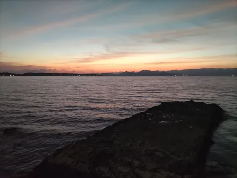 夕暮れ、静かな水辺の岩