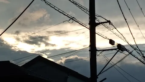空に伸びる無数の線、夕暮れの電線