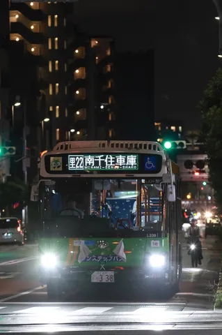 夜の街を走る緑のバス