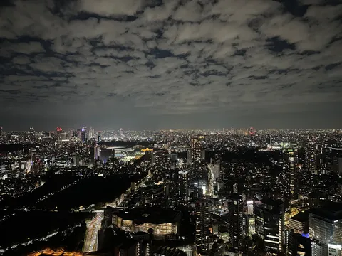 雲間から覗く、眠らない街の灯り