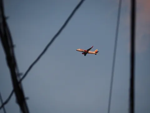 電線と飛行機雲、空を駆ける