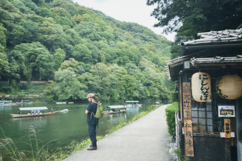 緑映える渓谷、川舟と旅人