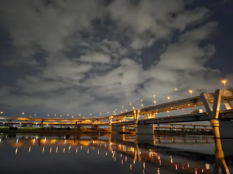 夜の水面に映る高架の灯
