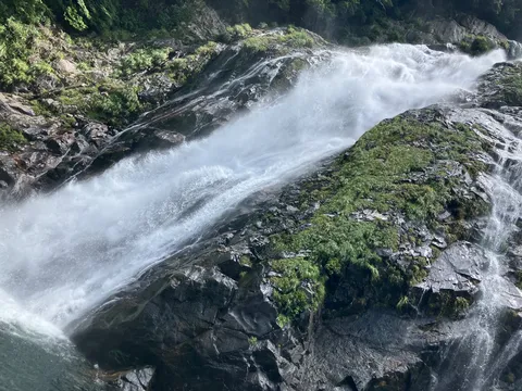 滝と岩肌の緑影