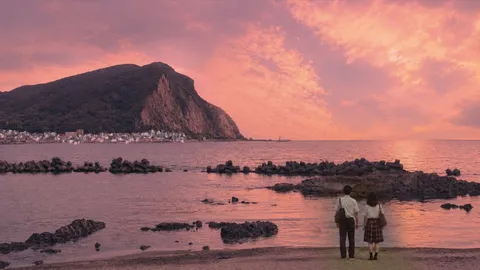 夕暮れの海辺、二人のシルエット