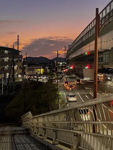 夕焼け空と都会の光が交錯する街並み