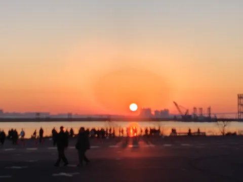 海辺の夕陽に集まる人々