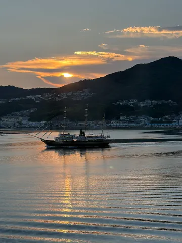 夕陽に染まる水面と古風な船