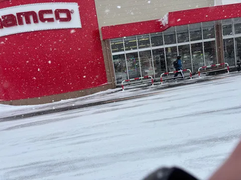雪降る道の赤い建物