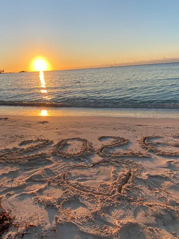 砂浜に刻んだ2022、水平線に沈む夕日