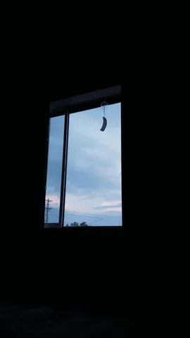 窓越しの夕暮れ、風鈴の影