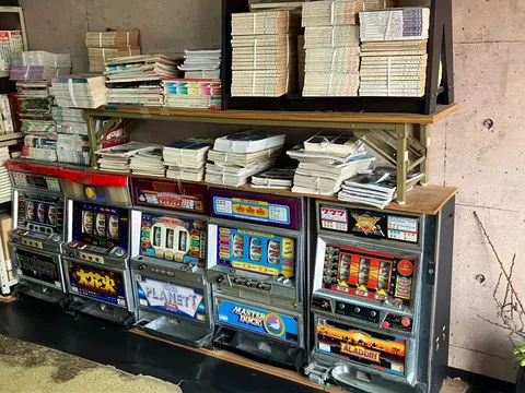 懐かしのレトロゲーム機と積み上げられた本たち