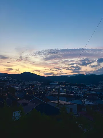 夕暮れの街と山影の語らい