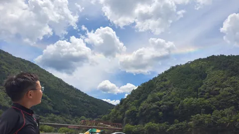 谷間に虹、少年が見つめる空