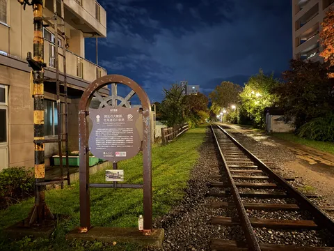 夜の線路と看板の静かな灯り
