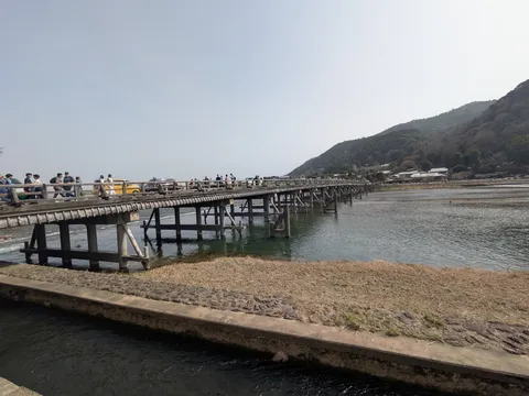 川面を渡る木造の橋と人々