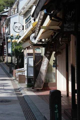 傾いた木製看板が導く路地裏