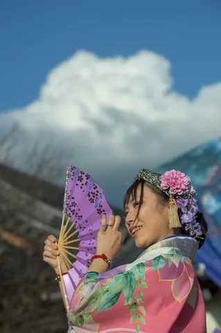風に舞う花と紫の扇