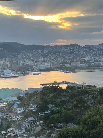 雲間から差し込む光、港町の夕景