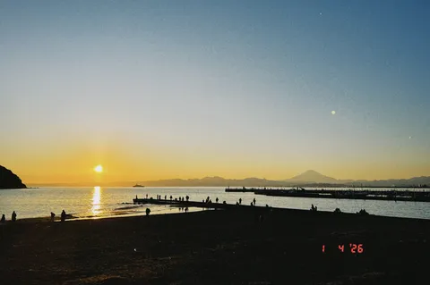 水平線に沈む夕日と人々