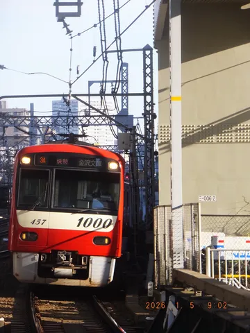 赤い電車が描く架線の影
