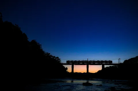 夕暮れを渡る鉄路の影